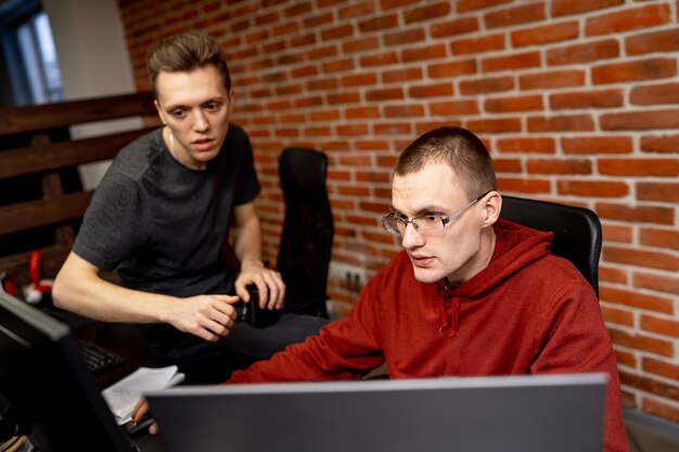 Jóvenes programadores hábiles mirando atentamente la pantalla. Concepto de tecnologías de codificación y desarrollo de programas