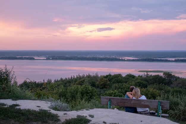 Los jóvenes que miran el paseo marítimo ven montañas y ríos, un ambiente natural.