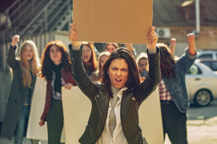 Foto jóvenes que protestan por los derechos de la mujer y la igualdad en la calle. las mujeres caucásicas se han reunido sobre problemas en el lugar de trabajo, presión masculina, abuso doméstico, acoso. copyspace. sosteniendo carteles.