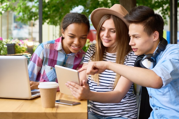 Jóvenes que usan dispositivos modernos en el café