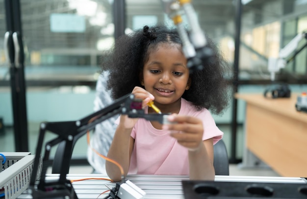 Los jóvenes que utilizan la tecnología del robot de mano se divierten aprendiendo la placa de circuitos electrónicos