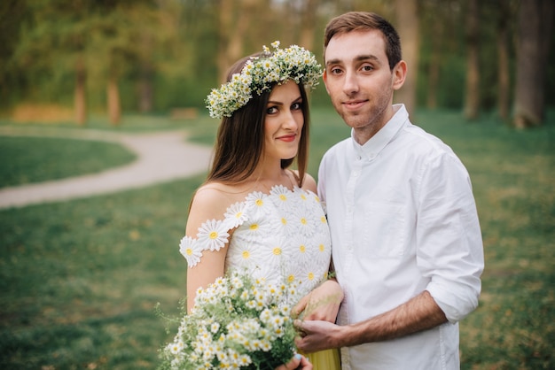 Jóvenes recién casados felices abrazándose en un parque de primavera, primer plano