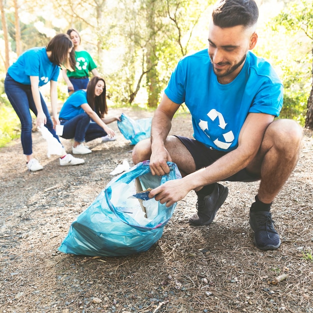 Jóvenes recogiendo basura en el bosque