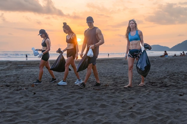 Jóvenes recogiendo basura en la playa Concepto de voluntariado Día Mundial del Medio Ambiente