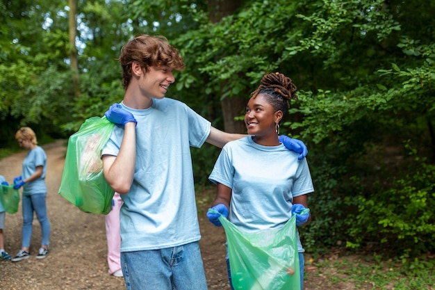 Jóvenes responsables haciendo trabajo de caridad comunitaria en el parque Grupo de personas limpiando juntas en un parque público salvando el medio ambiente