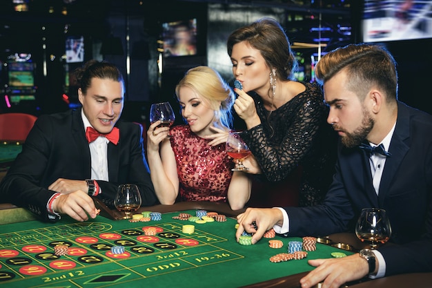 Jóvenes y ricos jugando a la ruleta en el casino