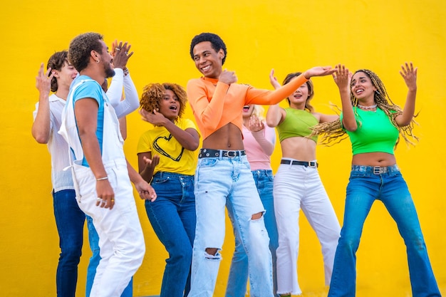 Foto jóvenes con ropas coloridas bailando juntos al aire libre