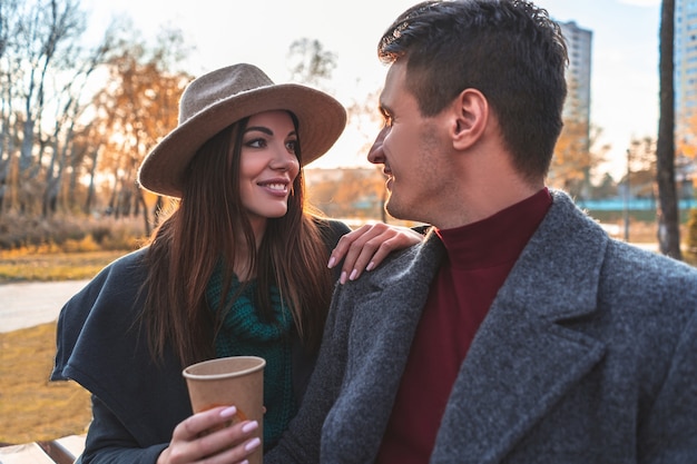 Los jóvenes sentados al aire libre con una taza de café