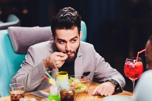 Jóvenes sentados en un café y hablando joven y mujer reuniéndose en la mesa del café