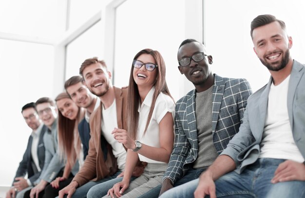 Jóvenes sentados en la pared esperando su turno en la entrevista.