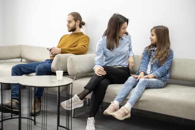 Jóvenes sentados en el sofá en la sala de espera de la clínica.