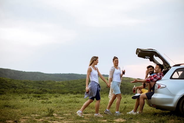 Jóvenes sentados en el tranvía del auto durante el viaje en la naturaleza