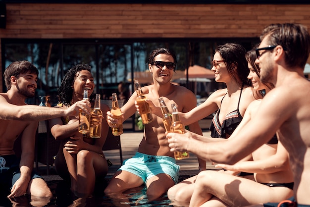 Jóvenes sonrientes gente sosteniendo botellas de cerveza