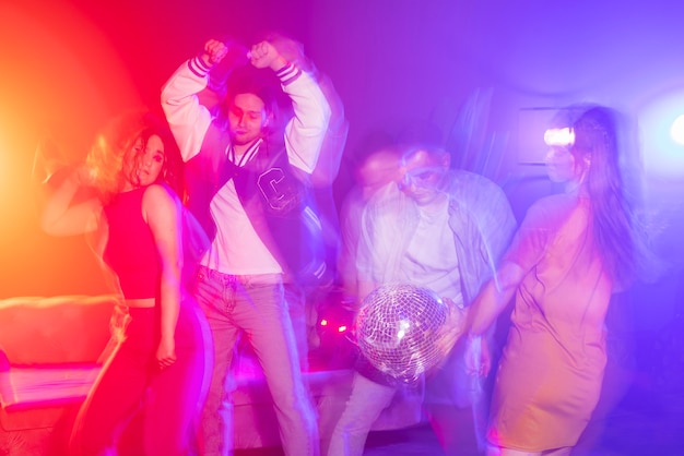 Foto jóvenes de tiro medio bailando en la fiesta.