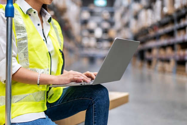 Jóvenes trabajadoras de almacén trabajando en una laptop en un gran almacén