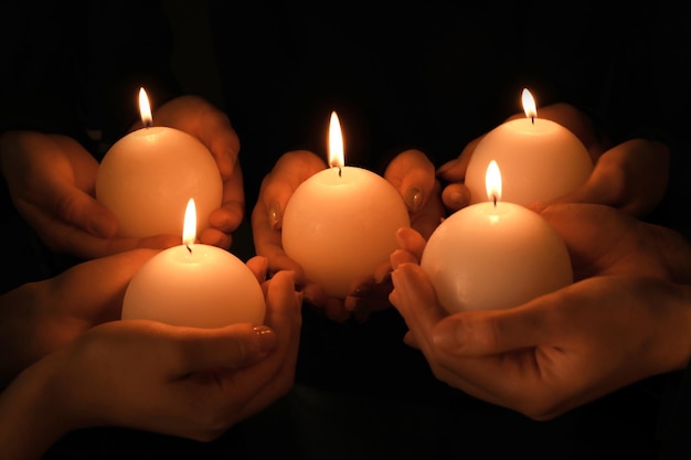 Jóvenes con velas encendidas en la oscuridad