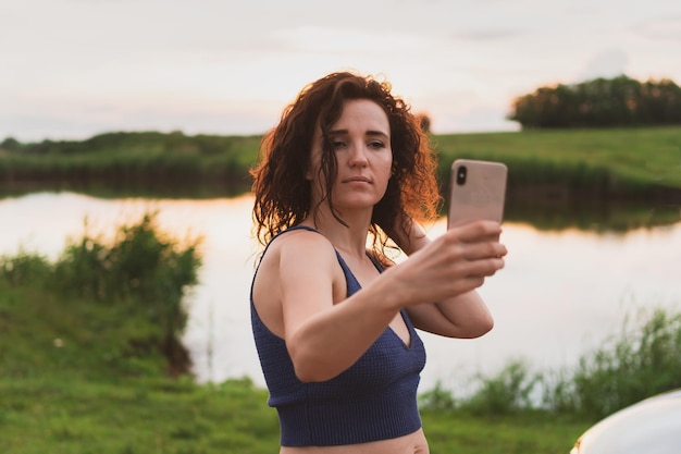 Las jóvenes viajeras son fotografiadas en un teléfono inteligente en la naturaleza