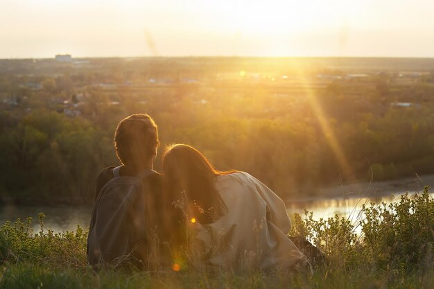 jóvenes viajeros chico con una chica fuera de la ciudad al atardecer disfrutan de la vista de la naturaleza