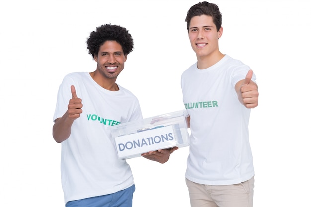 Jóvenes voluntarios sonrientes recogiendo donaciones