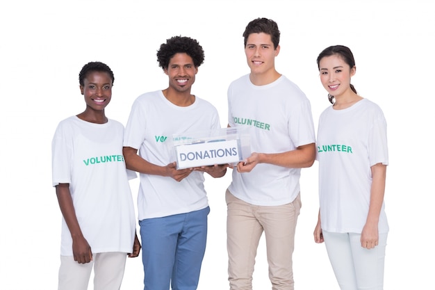 Jóvenes voluntarios sonrientes recogiendo donaciones