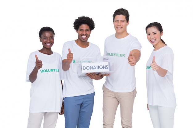 Jóvenes voluntarios sonrientes recogiendo donaciones