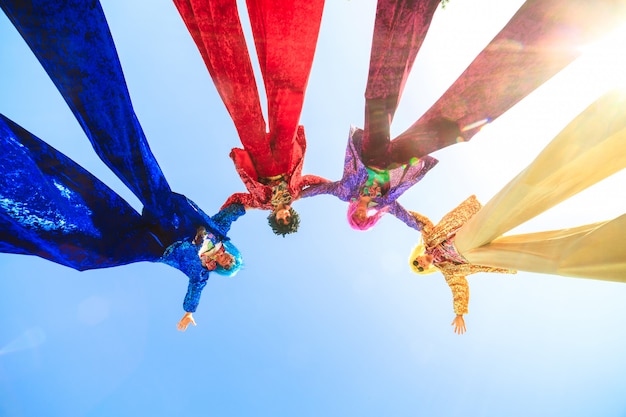 Jóvenes en zancos posando contra el cielo azul.