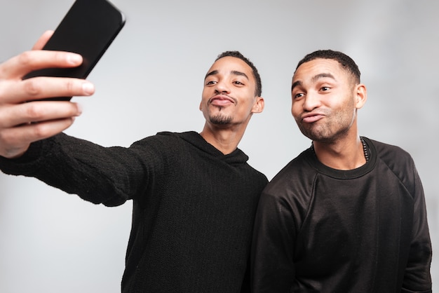 Jovens africanos engraçados fazem um selfie.