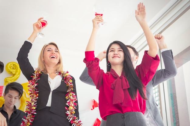 Jovens alegres que comemoram guardar flautas do champanhe.