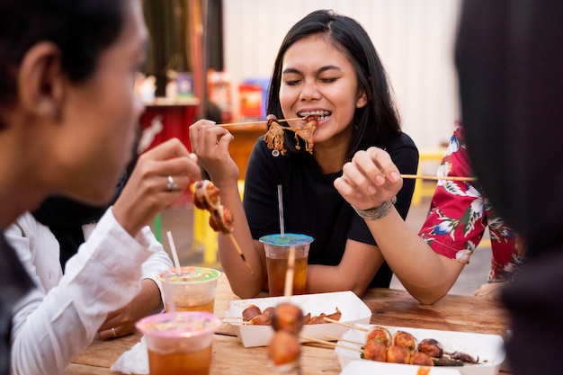 Foto jovens almoçam juntos na praça de alimentação ao ar livre