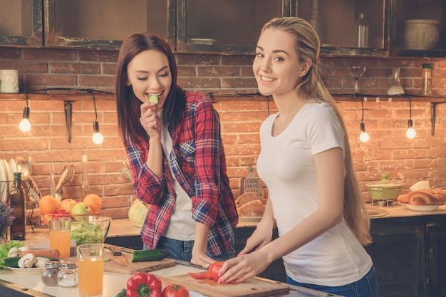 Jovens amigas cozinhando juntas em casa