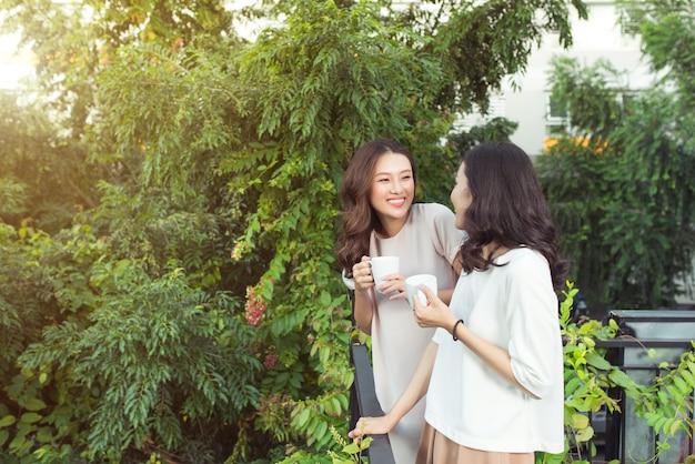 Jovens amigas felizes, bem vestidas e sorrindo juntas