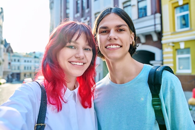 Jovens amigos adolescentes garoto e garota se divertindo rindo tirando foto de selfie