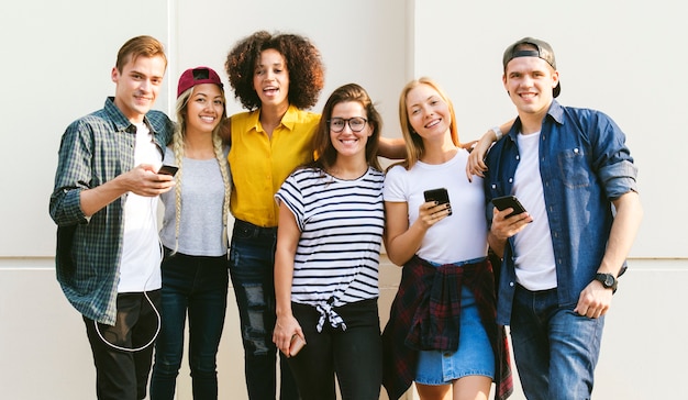 Jovens amigos adultos usando smartphones juntos ao ar livre conceito de cultura de juventude