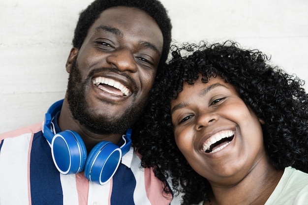 Jovens amigos africanos sorrindo para a câmera ao ar livre - foco nos rostos