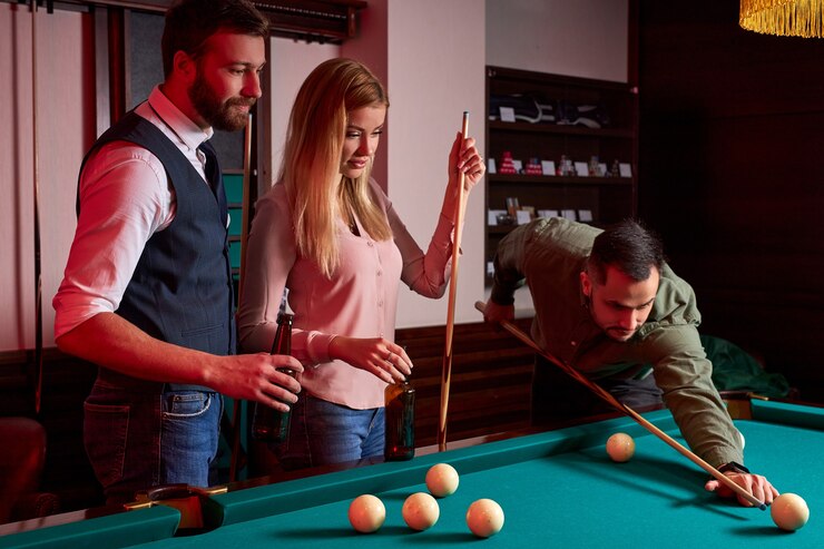 Foto jovens amigos ativos jogam bilhar no bar depois do trabalho, têm tempo de descanso e folga, preparando-se para atirar bolas de bilhar
