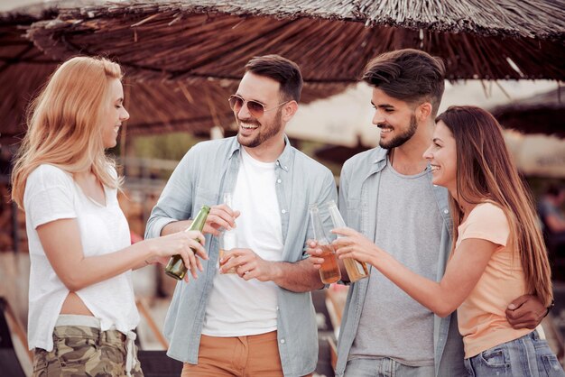 Jovens amigos bebendo cerveja e se divertindo ao ar livre