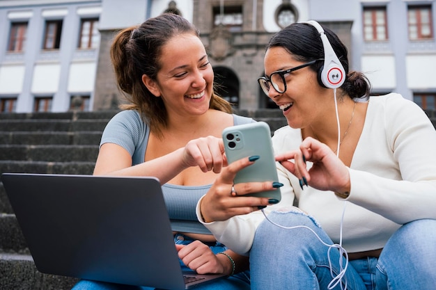 Jovens amigos da faculdade olhando para o telefone no campus