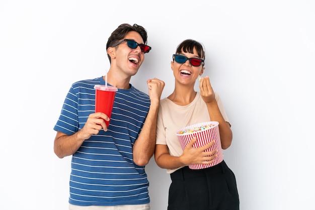 Jovens amigos de raça mista isolados em um fundo branco com óculos 3D e segurando um grande balde de pipocas