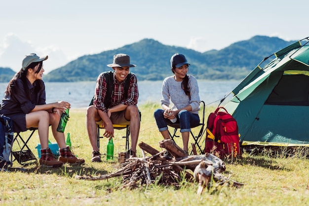 Jovens amigos felizes na festa da barraca de acampamento se divertindo juntos e bebendo cerveja no verão de férias