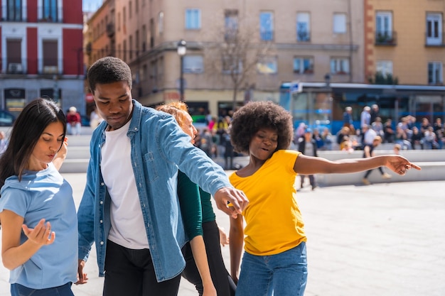 Jovens amigos multiétnicos dançando na cidade autêntico grupo de diversos amigos se divertindo