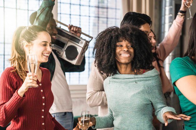 Jovens amigos multiétnicos fazendo uma festa em casa juntos Pessoas diversas engraçadas se divertindo dançando e cantando na sala de estar durante uma festa legal Conceito de estilo de vida da juventude Filtro brilhante