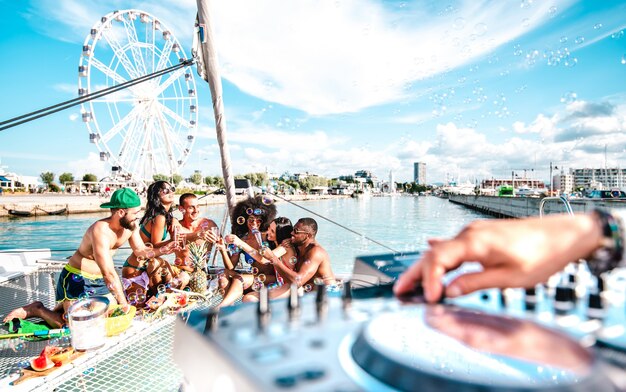 Jovens amigos se divertindo brindando vinho na festa do barco à vela