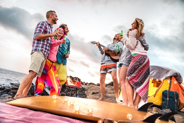 Jovens amigos se divertindo na festa de acampamento na praia