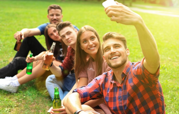 Jovens amigos tomando selfie durante piquenique de churrasco