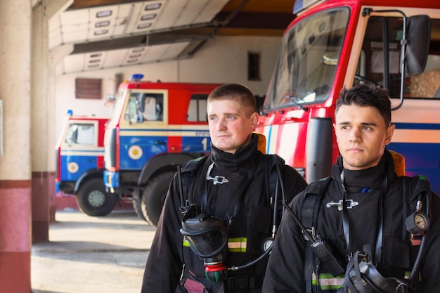 Jovens bombeiros sobre os carros de bombeiros