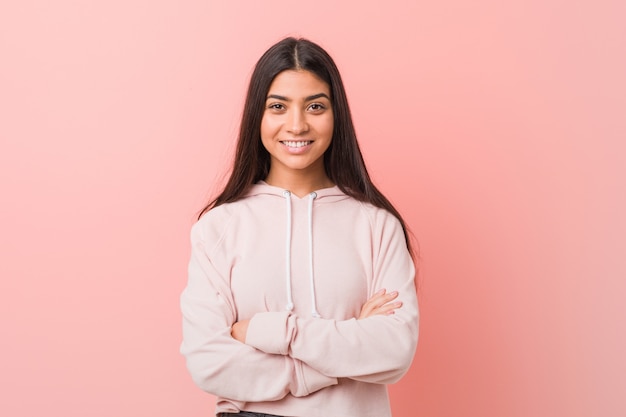 Jovens bonitas mulher árabe, vestindo um olhar casual esporte que se sente confiante, cruzando os braços com determinação.