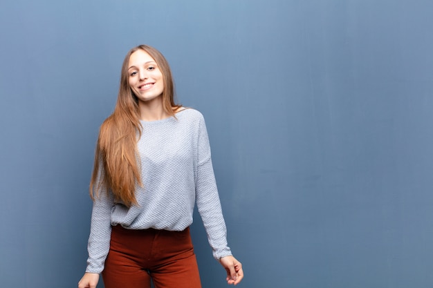 Jovens bonitas mulher contra a parede azul com um espaço de cópia