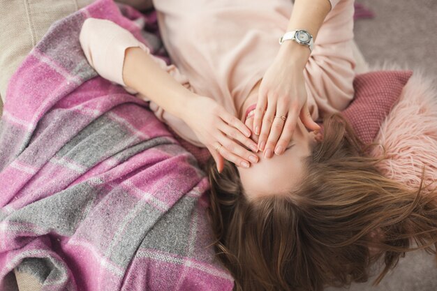 Jovens bonitas mulher descansando em casa. Moça bonita, deitado no sofá