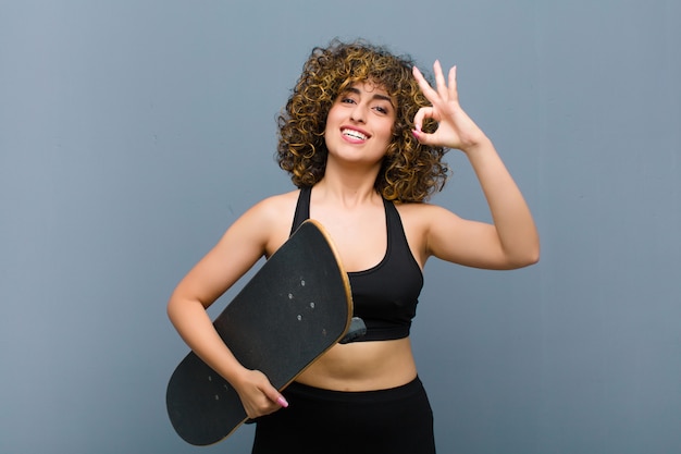 Jovens bonitas mulher esportes vestindo roupas fitness com um skate