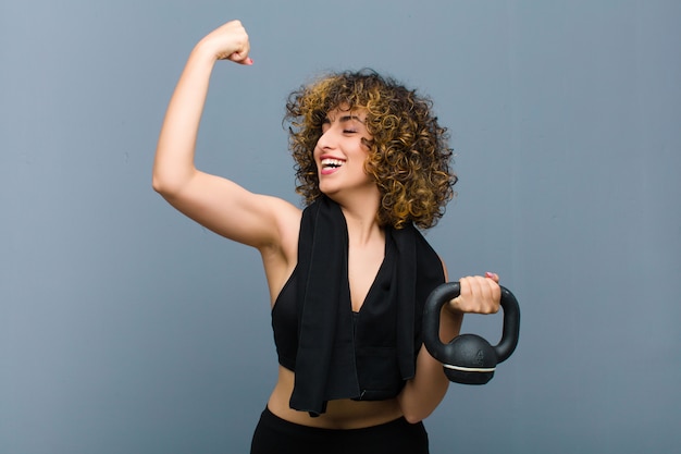 Jovens bonitas mulher esportes vestindo roupas fitness, levantando um haltere